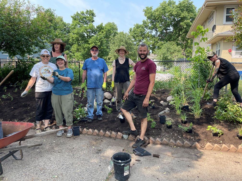Volunteers in front of pollinator garden